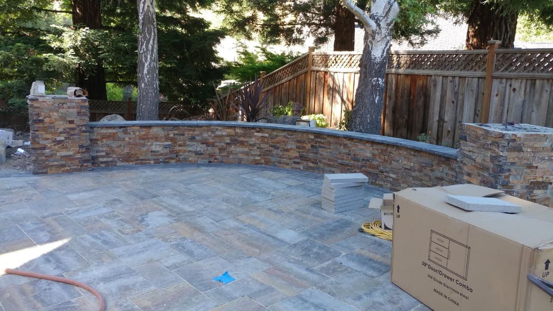 picture of a backyard deck with a custom backsplash retaining paver wall in stockton california