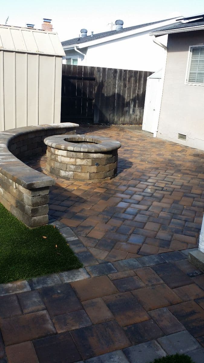 picture of backyard in stockton california that has been remodeled with custom pavers and has a paver fireplace