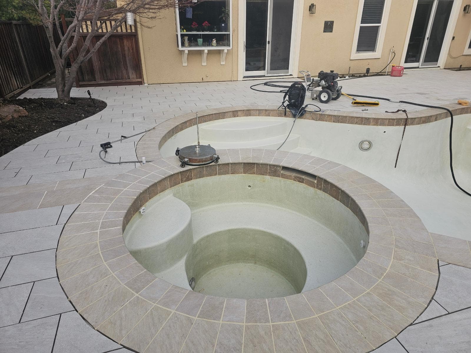 picture of a pool and backyard deck pavers being installed around the pool in stockton calironia