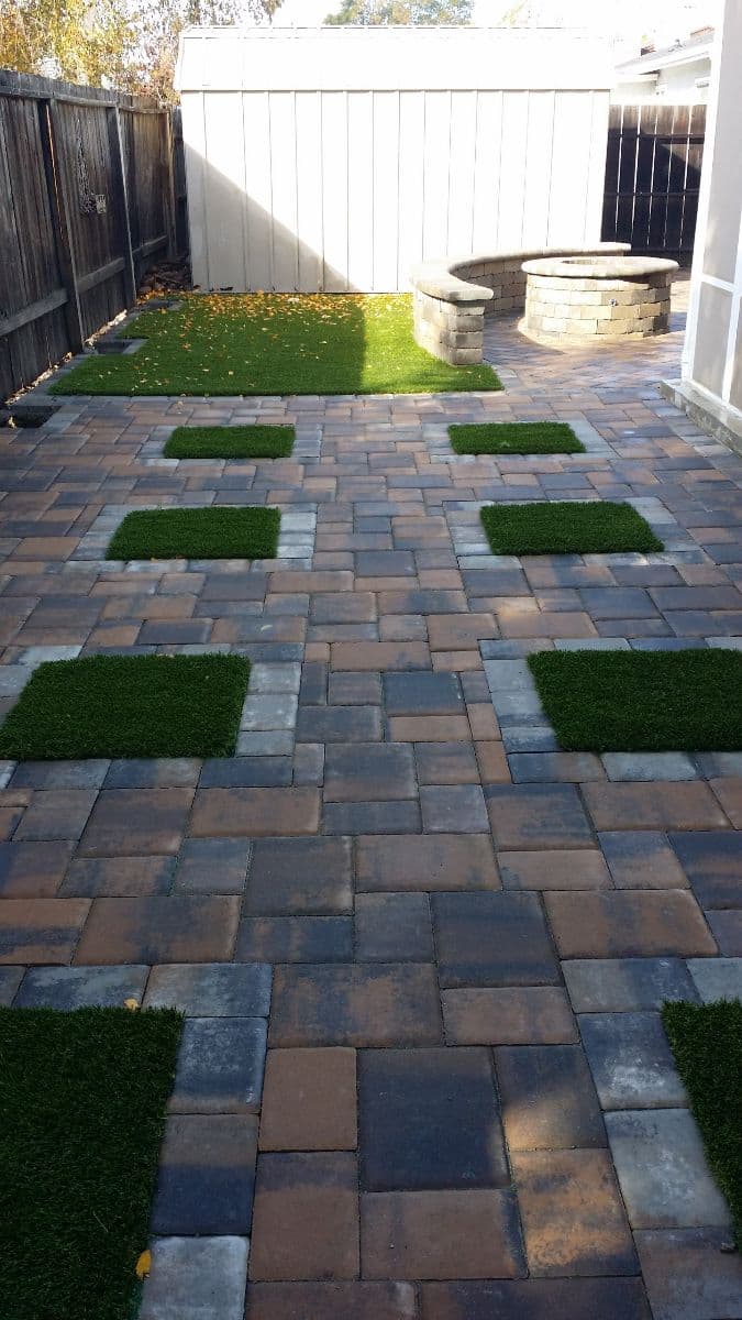 picture of a backyard in stockton california with beautiful textured paver walkway installed with a paver fireplace and bench